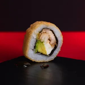 TROPICAL TORI ROLL apanado en panko, relleno de pollo teriyaki, queso crema y palta. Topping de salsa y semillas de maracuyá.