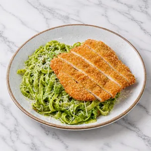 Fetuccini al pesto con milanesa de pollo