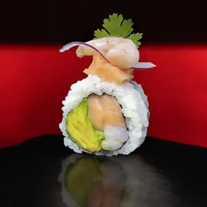 Cevichero Roll Nikkei con topping de ceviche de salmón y camarón y cilantro, relleno de salmón, camarón y palta. Sakai Sushi Providencia.