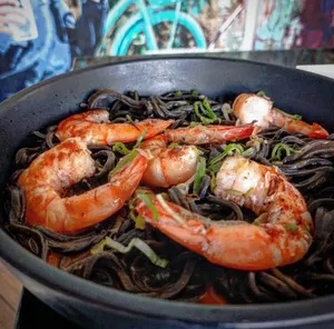 SPAGUETTI NERO TRUFADO CON CAMARONES GRILLA Y BISQUET DE CRUSTACEOS