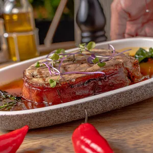 Porchetta Rostizada con Especias, Reducción de Panela y Vino