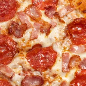 Pizza Todas Las Carnes con nuestro Pepperoni importando de USA, jamón, tocino, queso mozzarella y salsa de tomate.