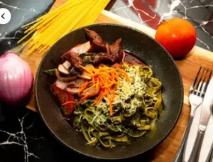 Fetuccini al pesto con lomo saltado