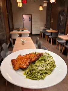 Tallarines pesto con chuleta frita