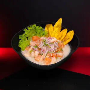 Ceviche FRESCOS DEL PACÍFICO con Salmón Coho Sureño y Camarón Ecuatoriano, marinado en Leche de Tigre, servido con camote frito y cancha.