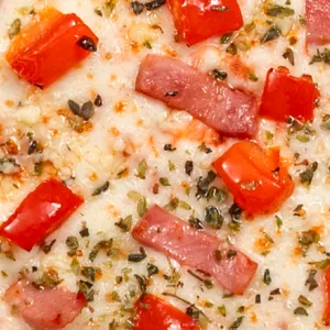 Pizza Italiana con jamón, tomate, un toque de orégano y parmesano, queso mozzarella y salsa de tomate.