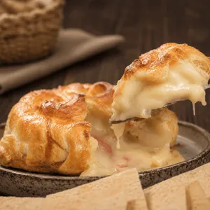 Camembert envuelto en masa relleno de prosciutto y peras